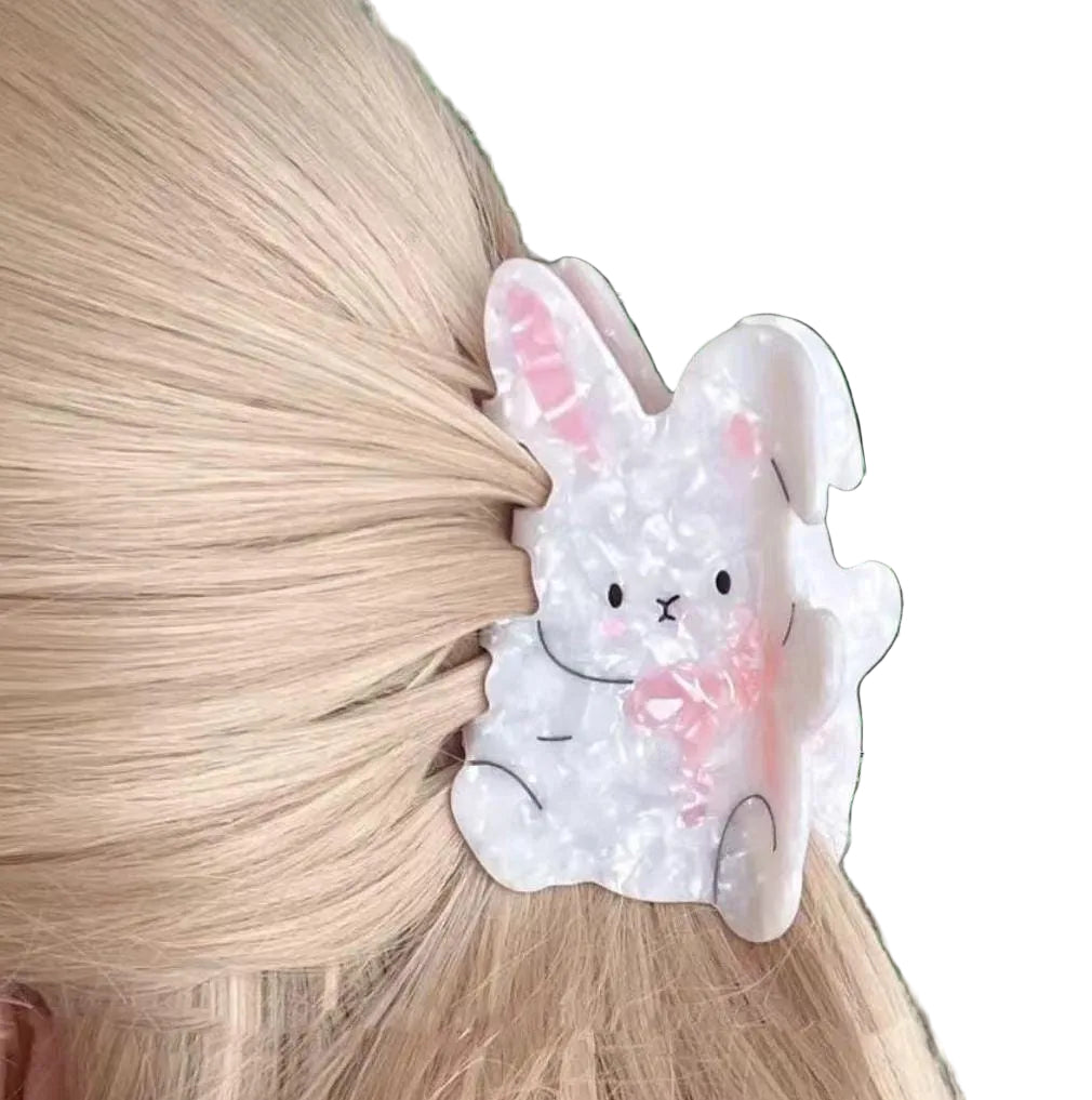 Hair clip shaped like a bunny with pink accents on a person's hair.